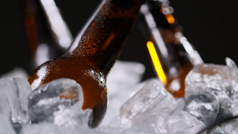 Nahaufnahme-Von-Glasflaschen-Mit-Kaltem-Bier-Oder-Alkoholfreien-Getränken,-Die-In-Einem-Mit-Eis-Gefüllten-Eimer-Vor-Schwarzem-Hintergrund-Kühlen-1